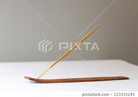 close-up on white background on a long brown stand with stars for incense sticks placed unused beige meditation stick with a pleasant smell in the room oriental aroma close-up on white background on a long brown stand with stars for incense sticks placed unused beige meditation stick with a pleasant smell in the room oriental aroma 123335293