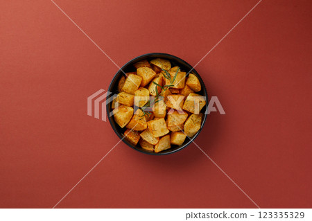 top shot on red background in a black plate, diced fried potatoes, rustic style, sprinkled with rosemary aromatic side dish, European cuisine top shot on red background in a black plate, diced fried potatoes, rustic style, sprinkled with rosemary aromatic side dish, European cuisine 123335329
