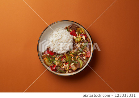 top shot on blue background black salad plate with Chinese rice and veal with vegetables sprinkled with nuts Asian cuisine healthy eating top shot on blue background black salad plate with Chinese rice and veal with vegetables sprinkled with nuts Asian cuisine healthy eating 123335331