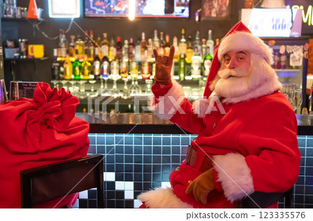 Santa Claus sits at the bar in a pub.  123335576