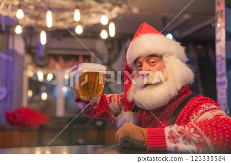 Santa Claus drinking beer at a bar.  123335584