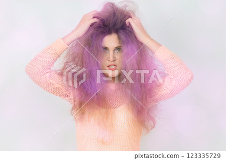 A woman with purple hair is wearing a pink shirt. 123335729