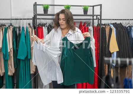 Caucasian fat woman chooses clothes. Plus size store. Caucasian fat woman chooses clothes. Plus size store. 123335791