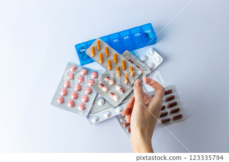 on white background on an outstretched female hand a silver blister with colored capsules suicidal thoughts depression health care pills in the air medical care others on the table pill box 123335794