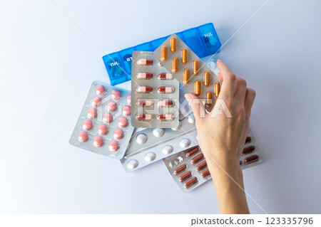 on white background on an outstretched female hand a silver blister with colored capsules suicidal thoughts depression health care pills in the air medical care others on the table pill box 123335796