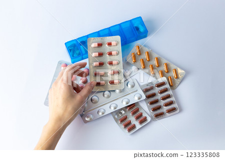 on white background on an outstretched female hand a silver blister with colored capsules suicidal thoughts depression health care pills in the air medical care others on the table pill box 123335808