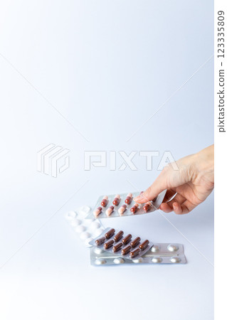 on white background on an outstretched female hand a silver blister with colored capsules suicidal thoughts depression health care pills in the air medical care others on the table 123335809