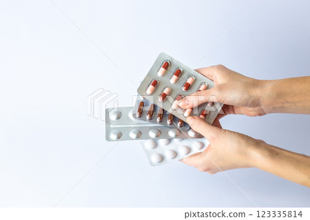 on white background on an outstretched female hands a silver blisters with colored capsules suicidal thoughts depression health care pills in the air medical care 123335814