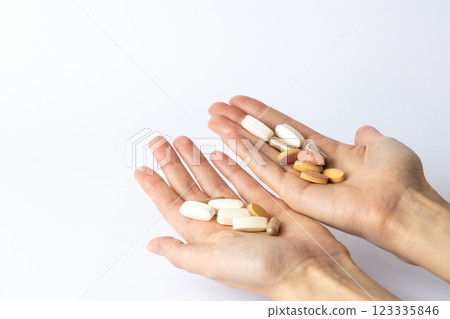 on white background, on the outstretched palms of female hands, there are pills and vitamins of different shapes and colors. suicidal thoughts, depression, health care. on white background, on the outstretched palms of female hands, there are pills and vitamins of different shapes and colors. suicidal thoughts, depression, health care. 123335846