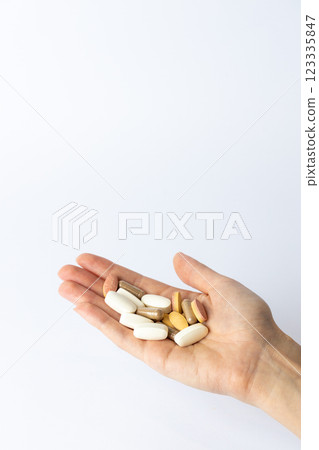 on white background, on the outstretched palm of the right female hand, there are pills and vitamins of different shapes and colors. suicidal thoughts, depression, health care. on white background, on the outstretched palm of the right female hand, there are pills and vitamins of different shapes and colors. suicidal thoughts, depression, health care. 123335847
