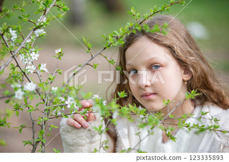 Portrait of a beautiful blue-eyed girl with spring flowers. 123335893