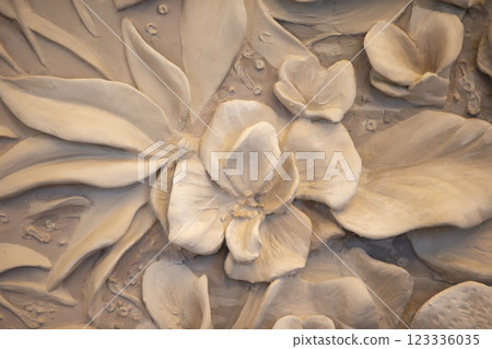 Texture of a decorative wall panel with flowers made of concrete and plaster. 123336035