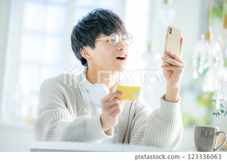 Young man looking at smartphone and credit card 123336063