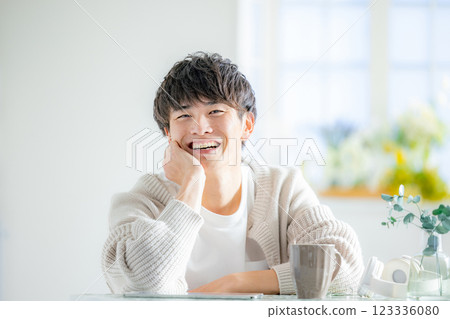 Smiling man resting his chin on his hands 123336080