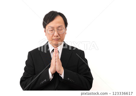 一個穿著西裝的男人默默祈禱 123336617