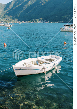 White fishing boat moored near the shore White fishing boat moored near the shore 123337412