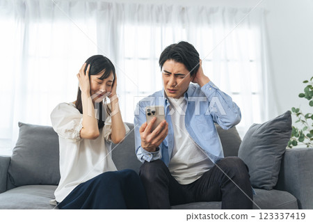 一對夫婦看著他們的智慧型手機，感到害怕 123337419