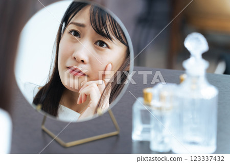 Woman checking her skin condition in the mirror 123337432
