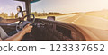 Truck driver sitting behind the wheel and driving a vehicle. 123337652