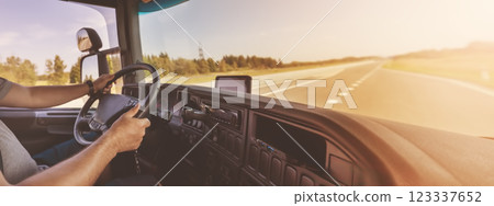 Truck driver sitting behind the wheel and driving a vehicle. 123337652