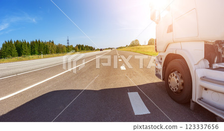 Closeup panoramic view of the white truck driving on the asphalt road. Closeup panoramic view of the white truck driving on the asphalt road. 123337656