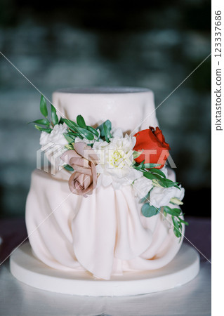 Wedding cake decorated with flowers stands on the table Wedding cake decorated with flowers stands on the table 123337686