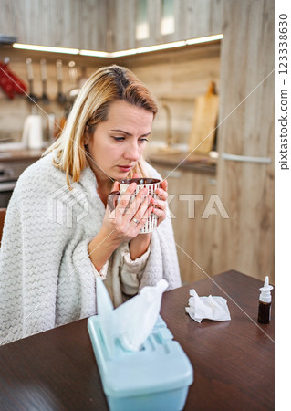 Cozy morning with a warm beverage and healing supplies in a kitchen Cozy morning with a warm beverage and healing supplies in a kitchen 123338630