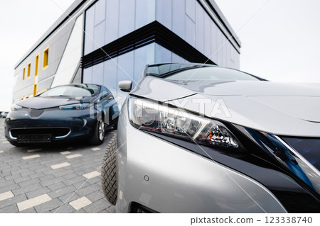 Side view of electric cars hood standing beside new cars for sell outdoors. Choosing and buying new car concept 123338740