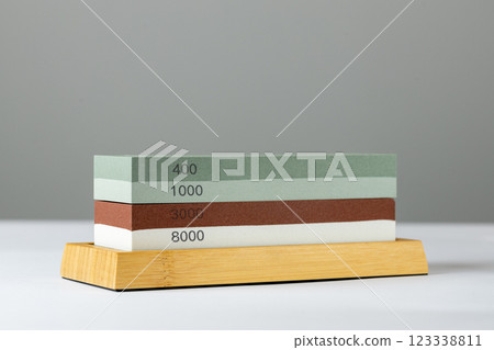grey background on table lies red and green equipment a set for sharpening and polishing kitchen knives and various blades different abrasiveness of stones a retainer for knives grey background on table lies red and green equipment a set for sharpening and polishing kitchen knives and various blades different abrasiveness of stones a retainer for knives 123338811