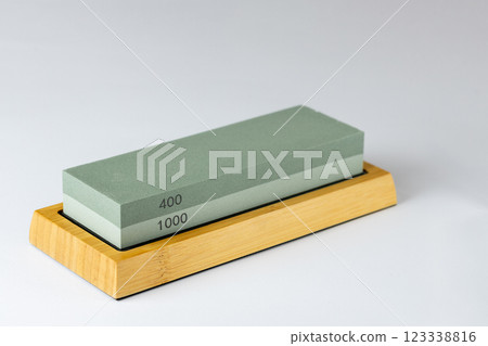closeup white background on table lies green equipment a set for sharpening and polishing kitchen knives and various blades different abrasiveness of stones a retainer for knives 123338816
