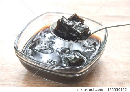black grass jelly Chinese cold sweetmeat in syrup in glass bowl black grass jelly Chinese cold sweetmeat in syrup in glass bowl 123339112