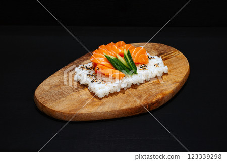 Creative minimalist display of sushi chirashi on a wooden platter against a dark backdrop, emphasizing vibrant colors and exquisite Japanese culinary art with a modern aesthetic. 123339298