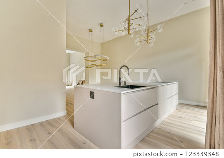 A sleek, contemporary kitchen showcasing a minimalist design with elegant fixtures and warm wooden flooring, creating an inviting atmosphere. 123339348