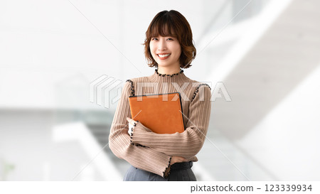 拿著活頁夾的微笑的婦女/女實業家 拿著活頁夾的微笑的婦女/女實業家 123339934