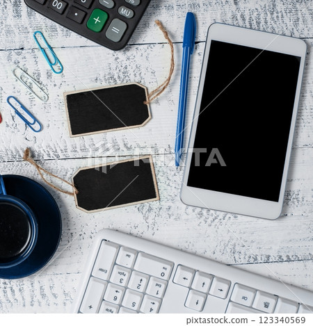 Phone With Important Message On Desk With Wood Tables And Clipboard. Cellphone Screen With Crutial Announcement. Calculator, keyboard, cup of coffee and pens. 123340569