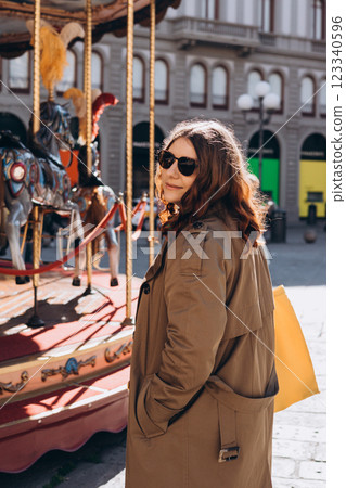 Cheerful young pretty woman in sunglasses with brown hair walking in park of attractions, wearing casual clothes Cheerful young pretty woman in sunglasses with brown hair walking in park of attractions, wearing casual clothes 123340596