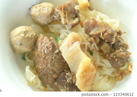 dry boiled thin rice noodles topping slice braised beef meat and tendon with meatball on bowl dry boiled thin rice noodles topping slice braised beef meat and tendon with meatball on bowl 123340612