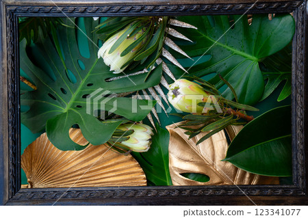 Tropical leaves and flowers over green background, summer background with copy space Tropical leaves and flowers over green background, summer background with copy space 123341077