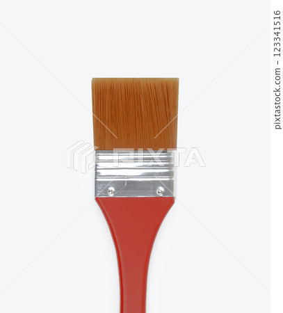 A flat paintbrush rests on a clean white surface ready for use A flat paintbrush rests on a clean white surface ready for use 123341516