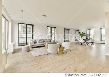 A spacious, contemporary living room showcasing elegant furniture, large windows for natural light, and a stylish dining area. The design emphasizes comfort and minimalism. A spacious, contemporary living room showcasing elegant furniture, large windows for natural light, and a stylish dining area. The design emphasizes comfort and minimalism. 123342156