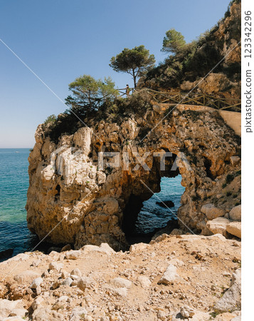 Stunning and Scenic Coastal Arch Landscape featuring Crystal Clear Blue Waters. Experience breathtaking coastal view boasting natural rock arch backdrop of serene blue sea. vertical, film look Stunning and Scenic Coastal Arch Landscape featuring Crystal Clear Blue Waters. Experience breathtaking coastal view boasting natural rock arch backdrop of serene blue sea. vertical, film look 123342296