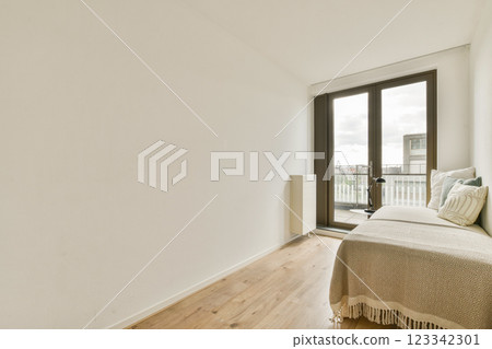A serene interior showcasing a minimalist aesthetic with soft natural light streaming through large windows, creating a calm atmosphere. 123342301