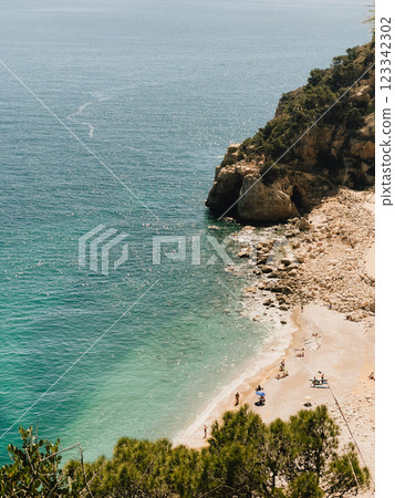 Enjoy serene coastal view featuring crystal clear water along with beautiful sandy beach. stunningly coastal scenery showcases turquoise waters alongside picturesque sandy shores. vertical, film look 123342302