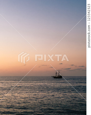 Serene and Colorful Sunset Over Tranquil Ocean Featuring Charming Sailing Ship. wonderfully peaceful sunset scene showcasing solitary ship gently sailing across calm serene waters. vertical, film look Serene and Colorful Sunset Over Tranquil Ocean Featuring Charming Sailing Ship. wonderfully peaceful sunset scene showcasing solitary ship gently sailing across calm serene waters. vertical, film look 123342323