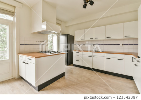 A sleek, modern kitchen featuring minimalist cabinetry and natural light pouring through the large window, emphasizing a clean and fresh atmosphere. A sleek, modern kitchen featuring minimalist cabinetry and natural light pouring through the large window, emphasizing a clean and fresh atmosphere. 123342387