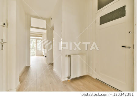 A spacious and bright hallway featuring light-colored walls and wooden flooring, creating a minimalist aesthetic that invites tranquility and openness. A spacious and bright hallway featuring light-colored walls and wooden flooring, creating a minimalist aesthetic that invites tranquility and openness. 123342391