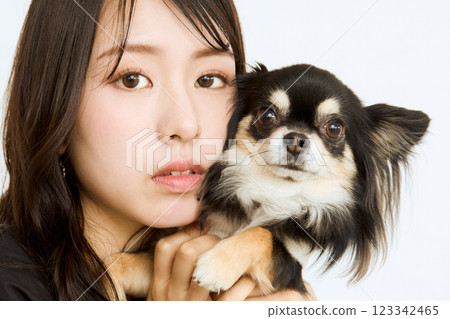 一名女子將寵物抱在臉頰旁 123342465