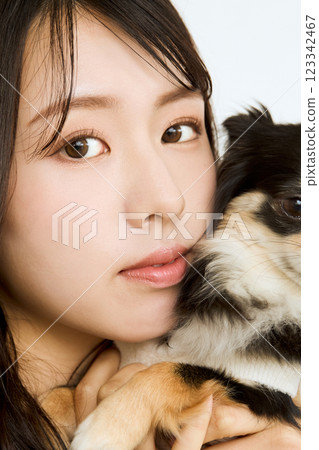 Woman holding her pet close to her cheek 123342467