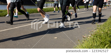 Motion blurred marathon runners in a city. Group of marathon runners compete in the race outdoors Motion blurred marathon runners in a city. Group of marathon runners compete in the race outdoors 123342527