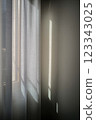 The soft morning light reflects off the quiet lace curtains 123343025
